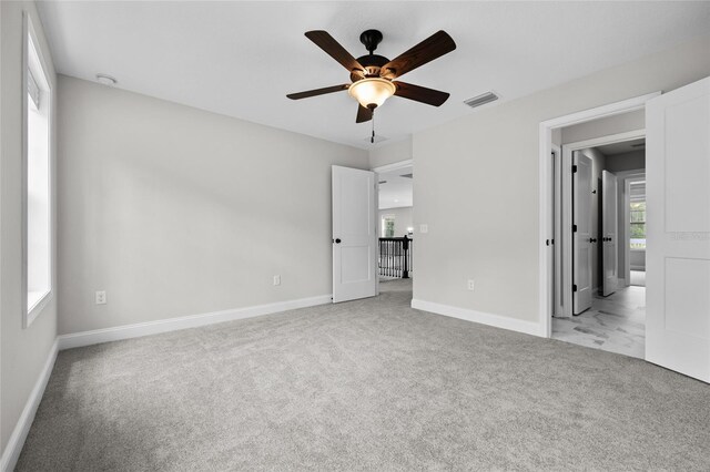 unfurnished bedroom featuring light colored carpet and ceiling fan