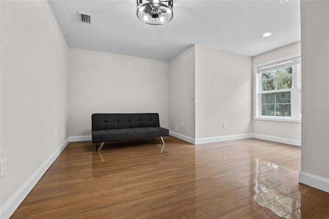 living area with a textured ceiling and hardwood / wood-style flooring