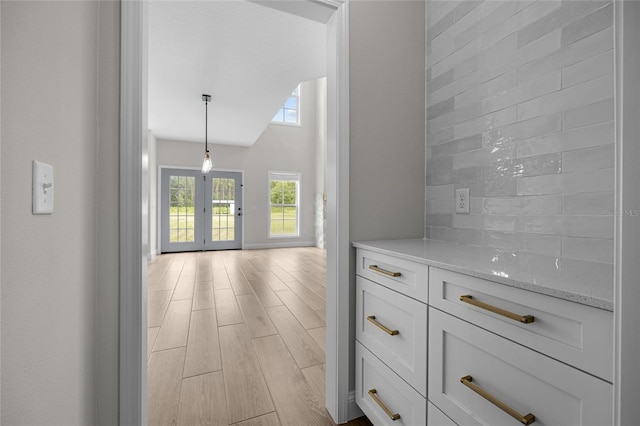 hall featuring light hardwood / wood-style flooring and vaulted ceiling