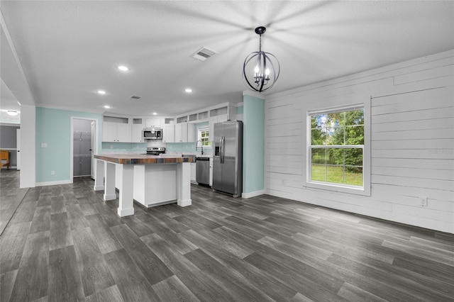 kitchen with white cabinets, dark wood-type flooring, wood counters, stainless steel appliances, and sink