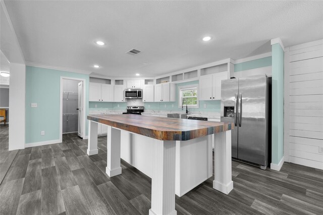 kitchen featuring white cabinetry, butcher block countertops, dark hardwood / wood-style floors, and stainless steel appliances