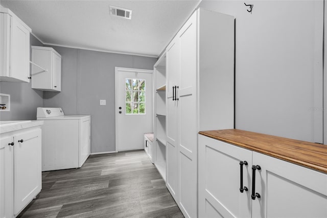 washroom featuring washer / clothes dryer, dark wood-type flooring, cabinets, and a textured ceiling