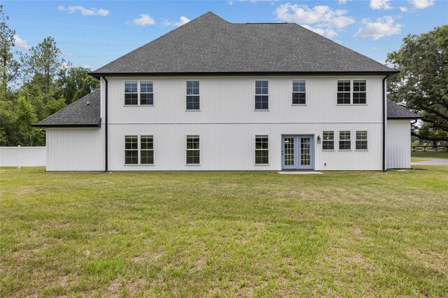 back of house featuring french doors and a lawn