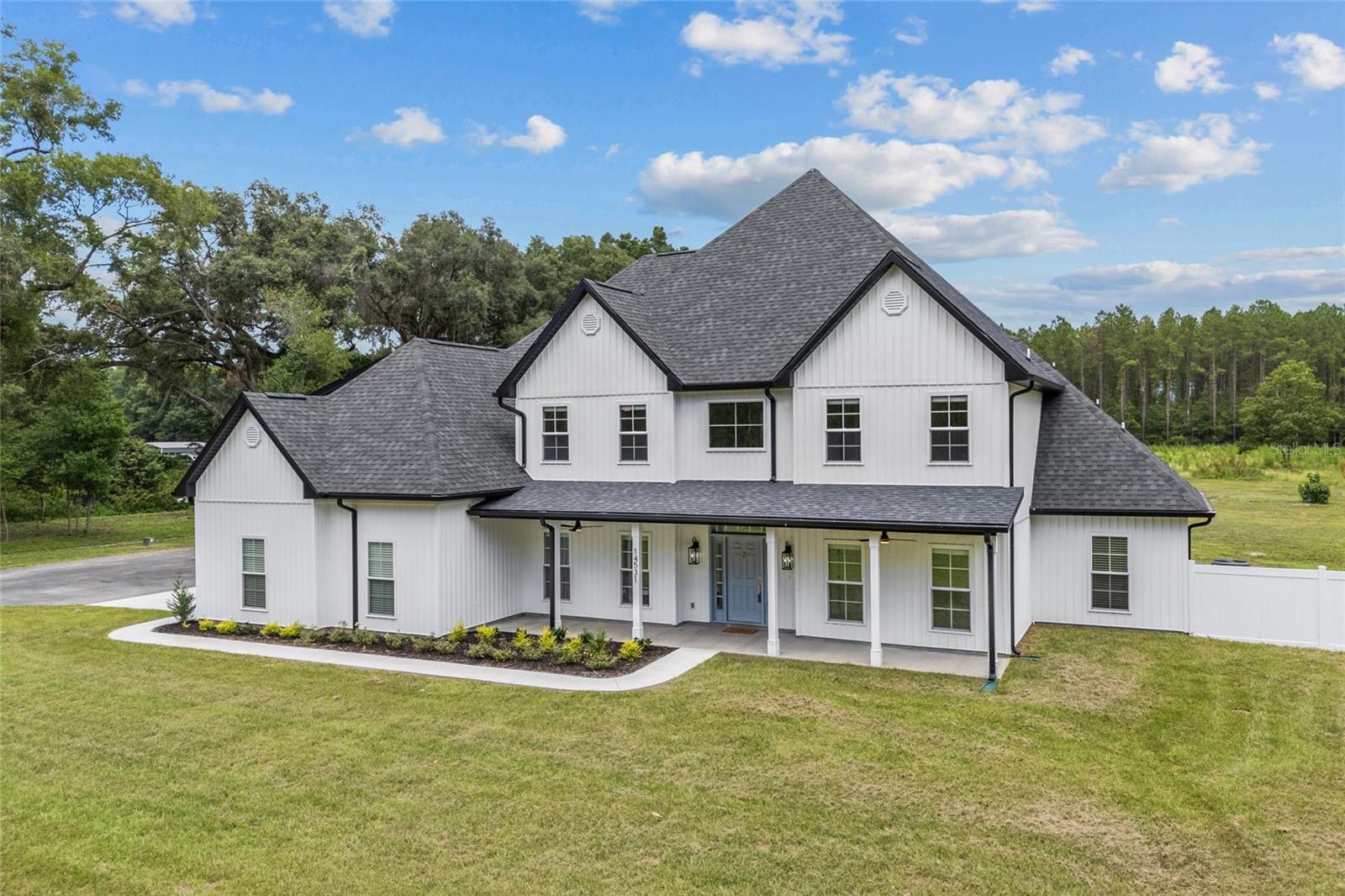 modern inspired farmhouse with a porch and a front lawn