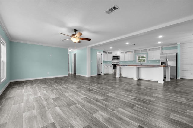 unfurnished living room with a textured ceiling, crown molding, hardwood / wood-style floors, and ceiling fan