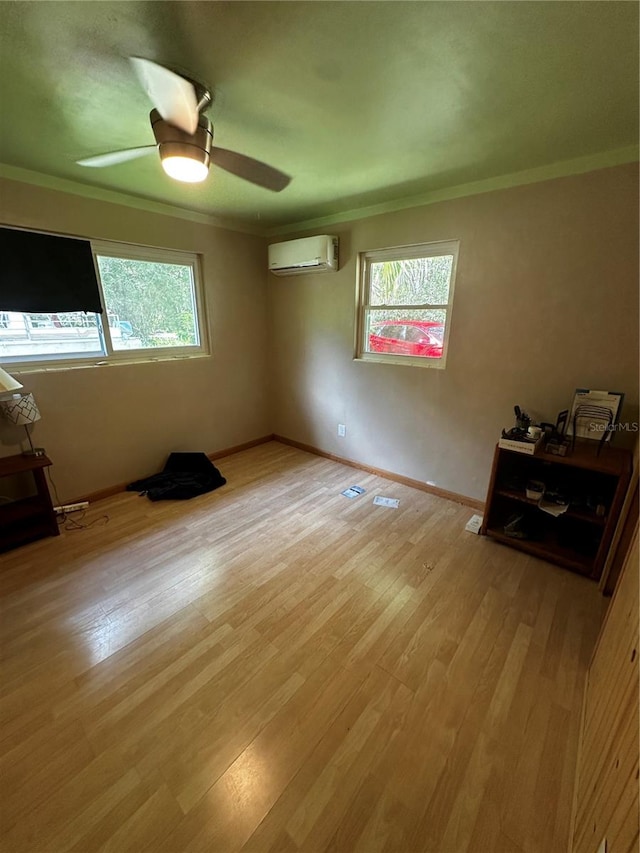 unfurnished bedroom featuring crown molding, a wall mounted AC, ceiling fan, and light hardwood / wood-style floors