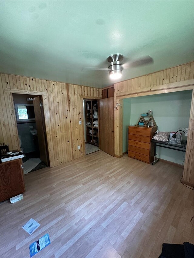 4215 NW 10th St, Gainesville, FL 32609 - bedroom featuring light wood finished floors, wood walls, and ceiling fan