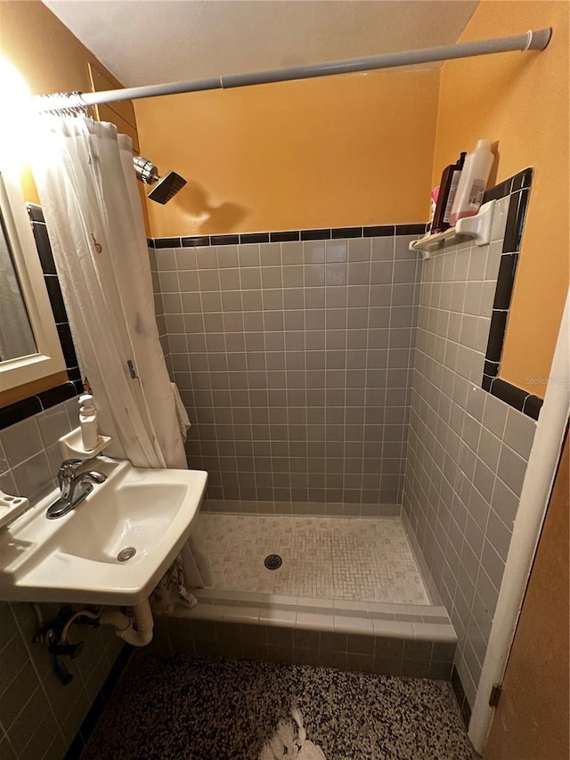 bathroom featuring sink, curtained shower, and backsplash