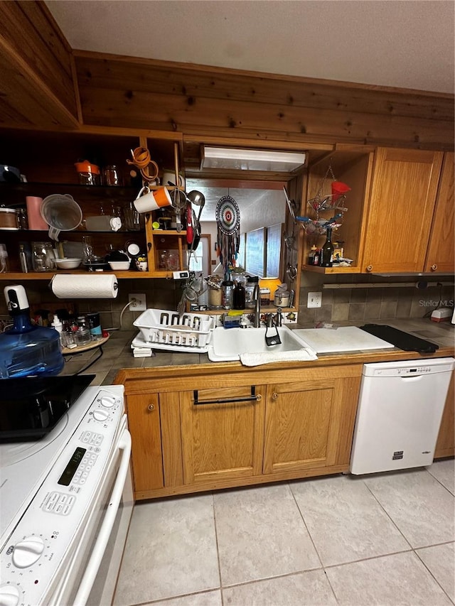 kitchen with sink, white appliances, backsplash, and light tile patterned flooring