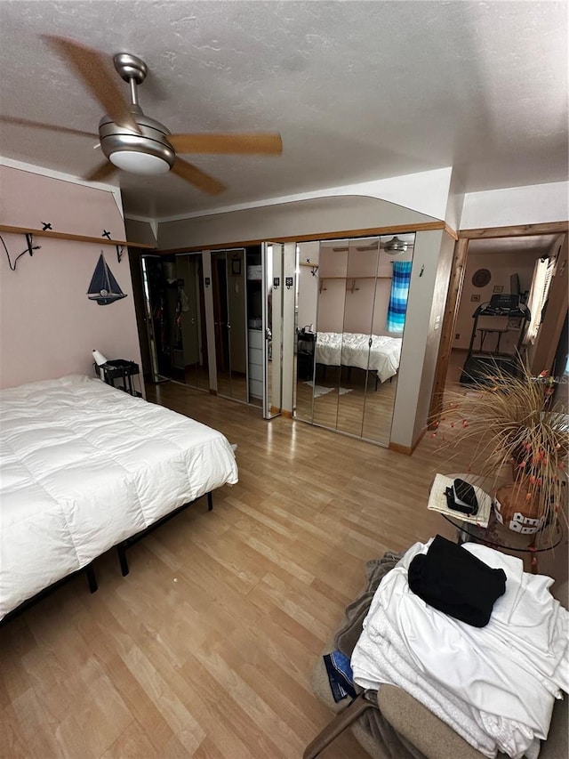 bedroom featuring wood-type flooring, ceiling fan, and a textured ceiling