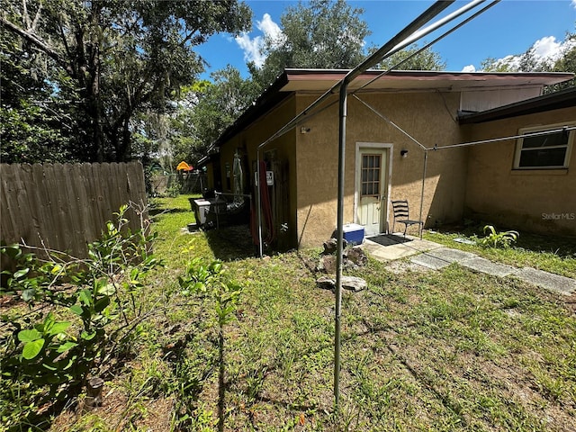 view of side of home with a yard