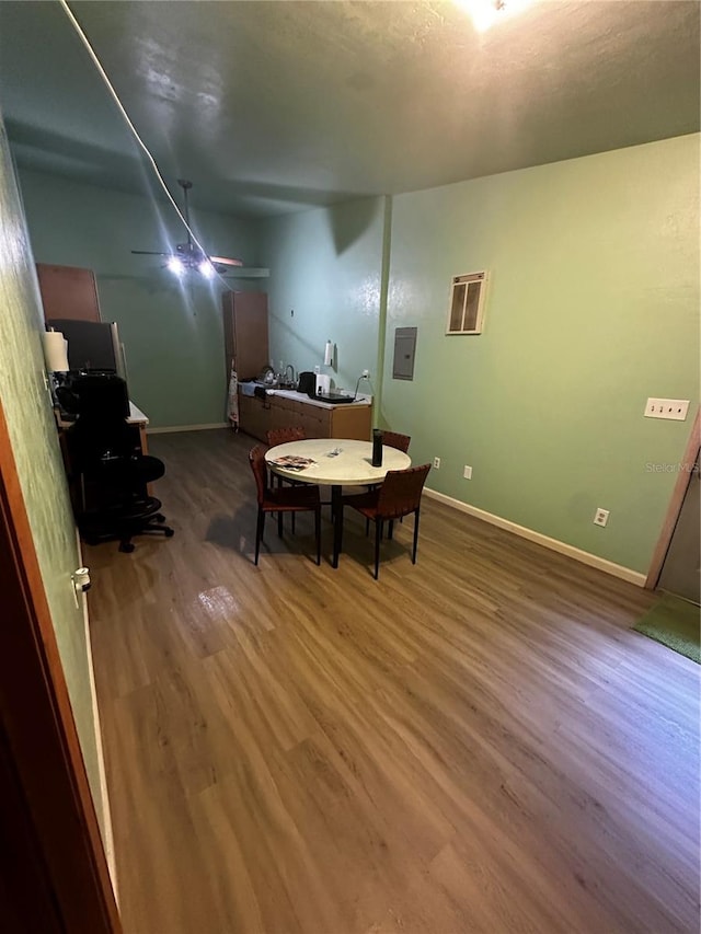 dining space with wood-type flooring and electric panel