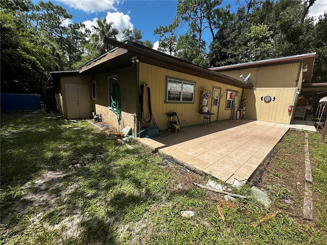 back of property featuring a lawn and a patio area