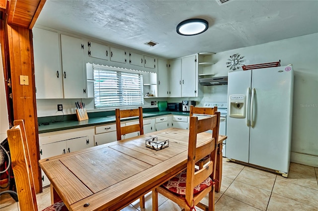 kitchen featuring light tile patterned floors, white cabinetry, and white appliances