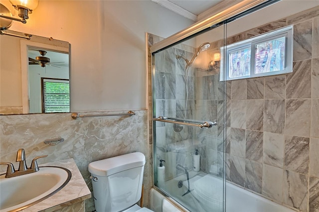 full bathroom with toilet, vanity, tile walls, combined bath / shower with glass door, and ornamental molding