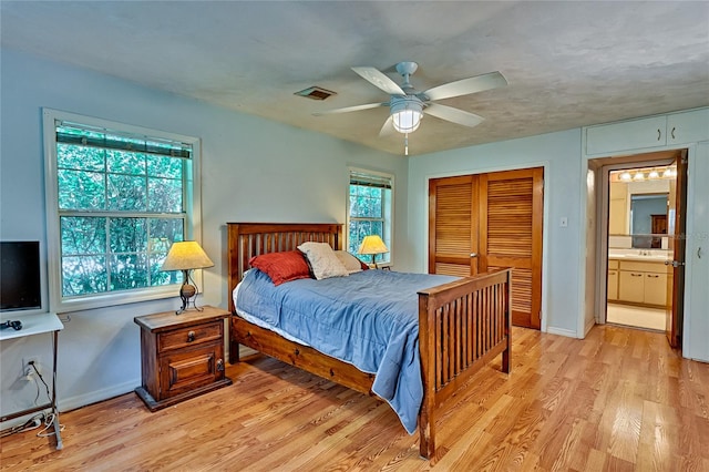 bedroom with light hardwood / wood-style floors, sink, a closet, ceiling fan, and ensuite bathroom