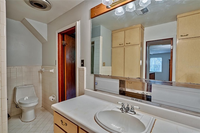 bathroom with toilet, tile walls, tile patterned floors, and vanity