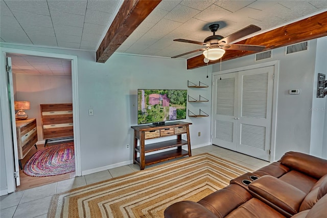 living room featuring ceiling fan, light tile patterned floors, and beam ceiling