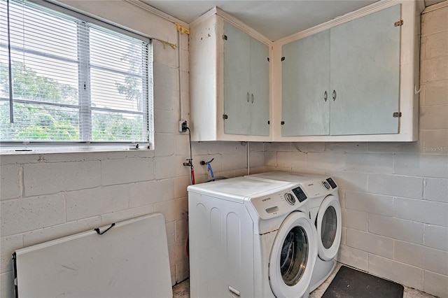 laundry room with independent washer and dryer, a wealth of natural light, and cabinets