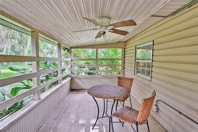 sunroom / solarium with ceiling fan and vaulted ceiling