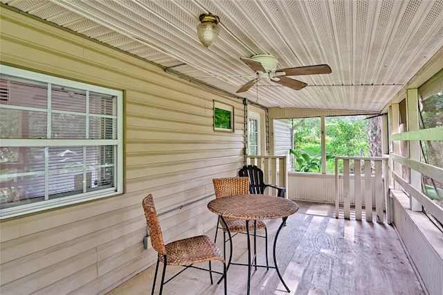 sunroom / solarium with vaulted ceiling, ceiling fan, and wooden ceiling