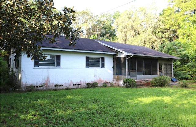 ranch-style home with a sunroom and a front yard