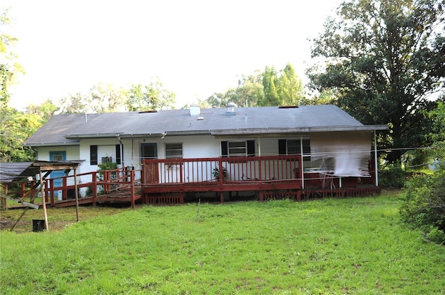 rear view of house with a deck and a yard