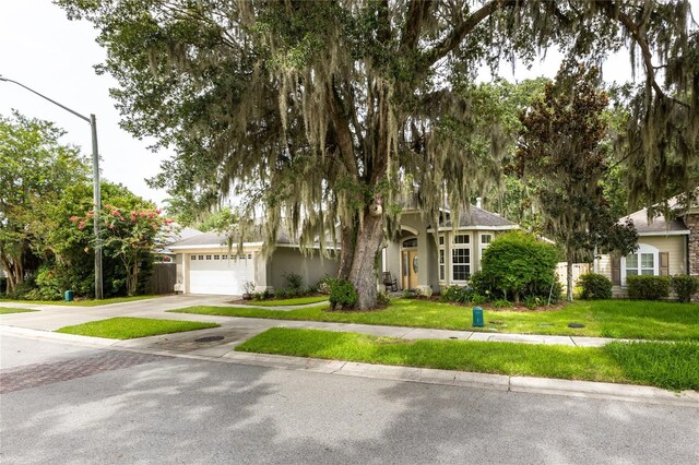 obstructed view of property featuring a garage and a front yard