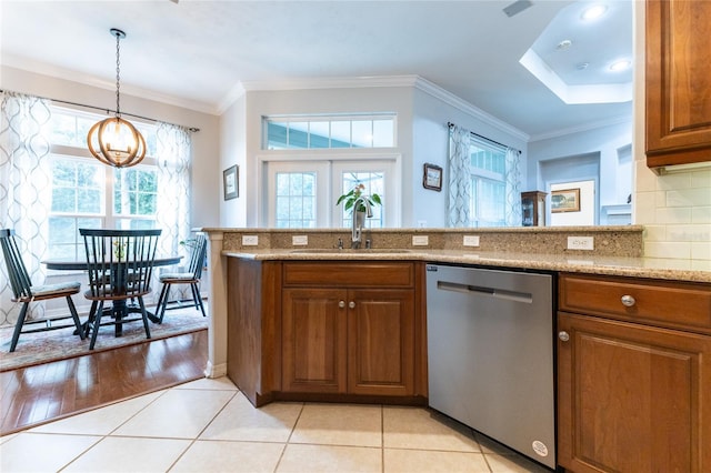 kitchen with ornamental molding, stainless steel dishwasher, light stone counters, and light hardwood / wood-style flooring