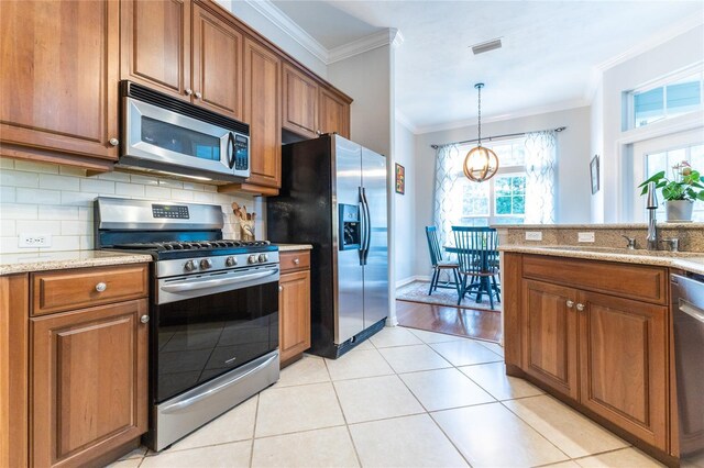 kitchen with crown molding, light wood-type flooring, light stone counters, stainless steel appliances, and sink