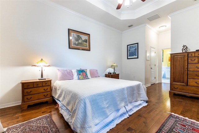 bedroom featuring crown molding, ceiling fan, dark hardwood / wood-style floors, ensuite bathroom, and a raised ceiling