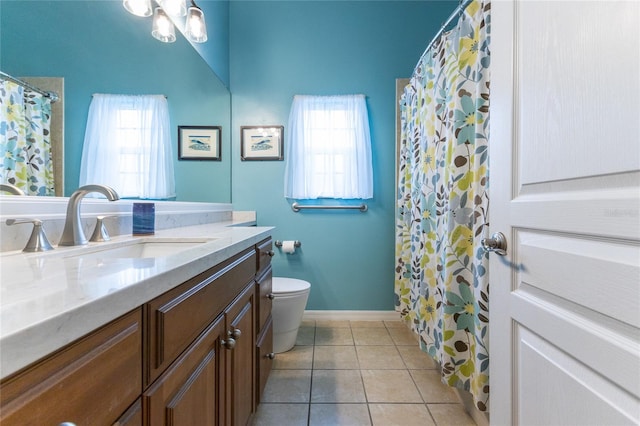 bathroom featuring vanity, a wealth of natural light, tile patterned flooring, and toilet