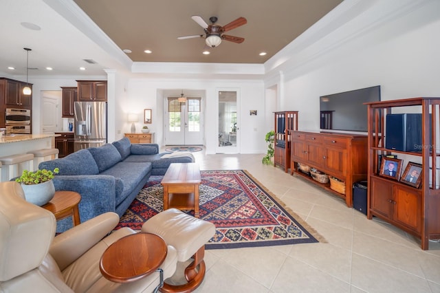 living room featuring a tray ceiling, french doors, ceiling fan, light tile patterned floors, and crown molding