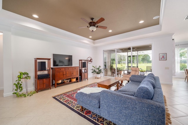 tiled living room with a raised ceiling and ceiling fan