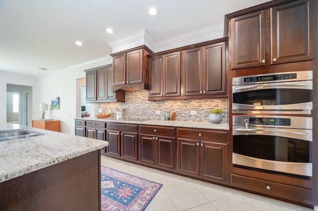 kitchen featuring backsplash, ornamental molding, light tile patterned floors, double oven, and black electric cooktop