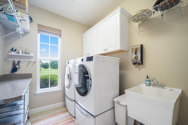 washroom featuring cabinets, light tile patterned floors, separate washer and dryer, and sink