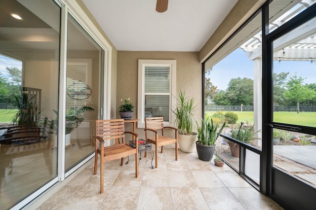 sunroom / solarium featuring ceiling fan