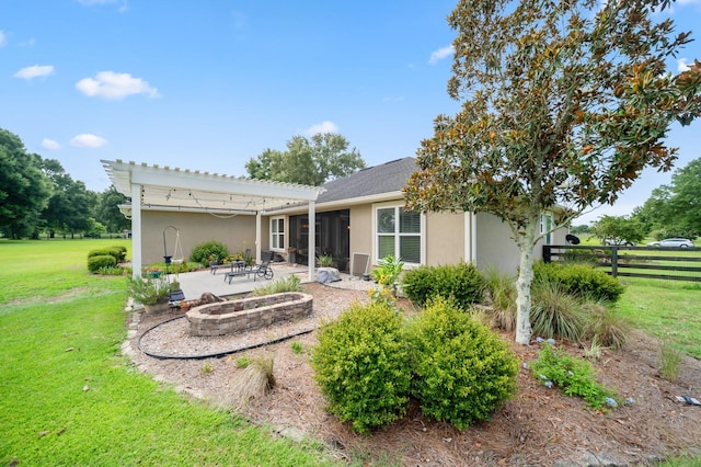 rear view of house with a fire pit, a sunroom, a lawn, a pergola, and a patio