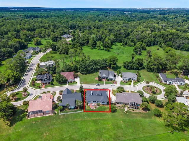 drone / aerial view featuring a wooded view and a residential view