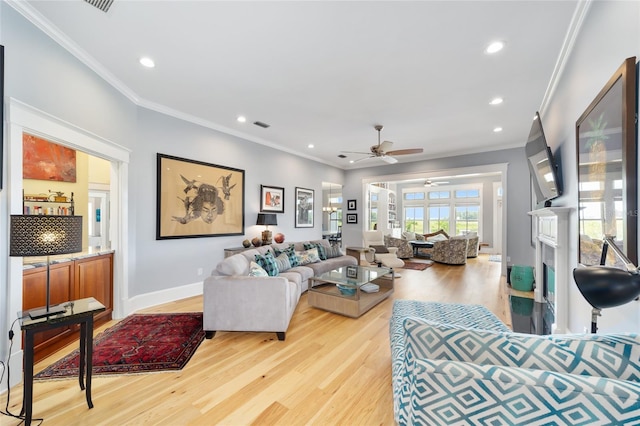 living room featuring crown molding, ceiling fan, and light wood-type flooring