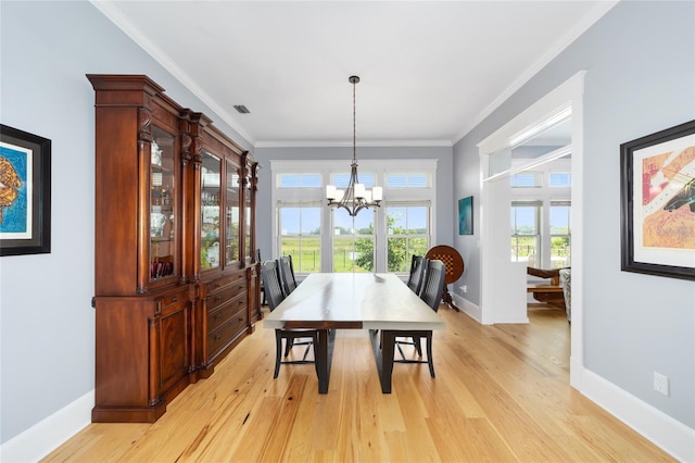 dining room featuring crown molding, a chandelier, and light wood-type flooring