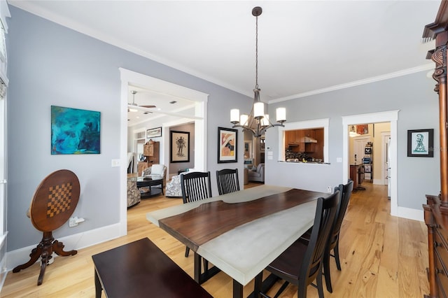 dining room with ornamental molding, light wood-type flooring, a chandelier, and baseboards