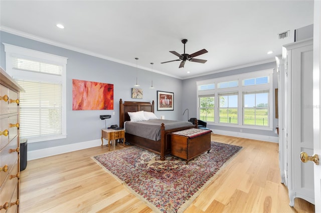 bedroom with light wood finished floors, visible vents, and ornamental molding