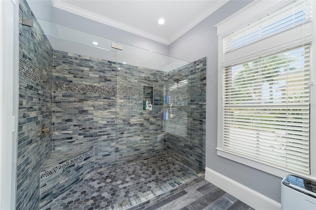 bathroom featuring ornamental molding, wood finished floors, baseboards, and walk in shower