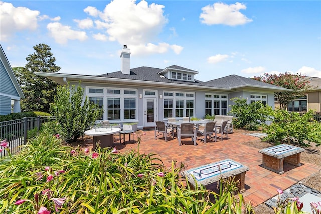 rear view of property with a patio, an outdoor fire pit, fence, and stucco siding