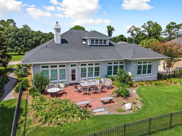 rear view of property featuring a fenced backyard, an outdoor hangout area, a shingled roof, a lawn, and stucco siding