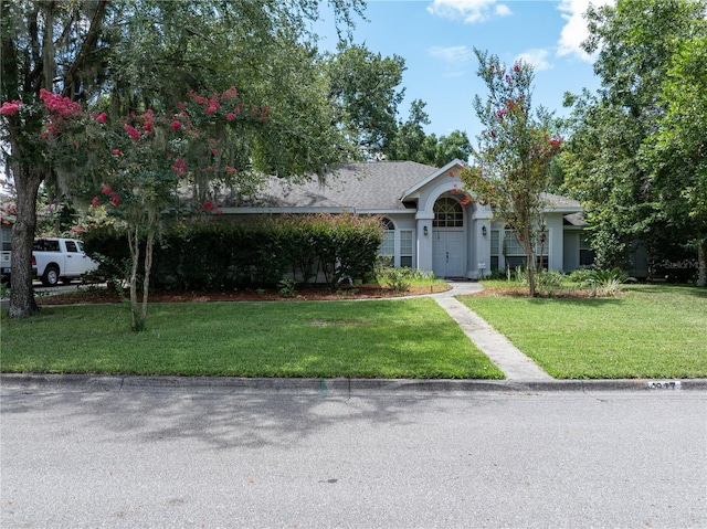 view of front of house with a garage and a front lawn