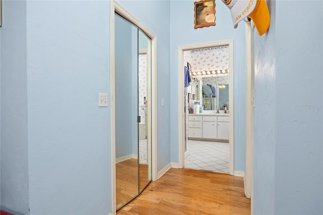 hallway featuring light tile patterned flooring and sink