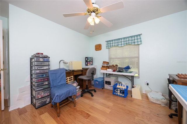 home office with light hardwood / wood-style flooring and ceiling fan