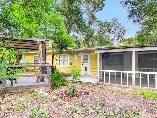 back of property featuring a sunroom and a deck